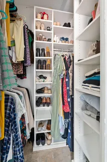 a view of walk in closet with clothes and shoes