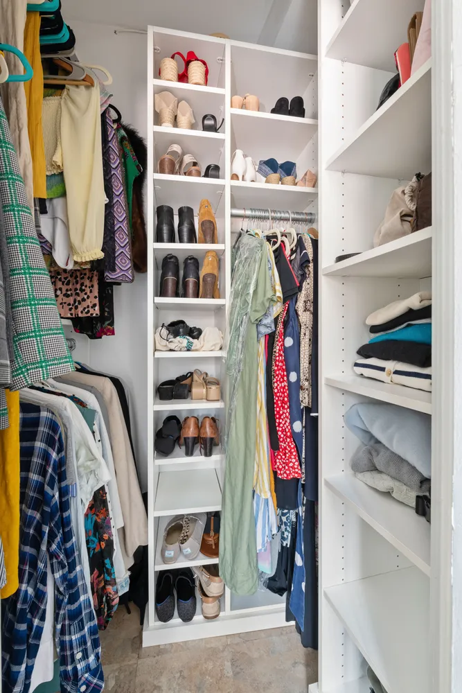 a view of walk in closet with clothes and shoes