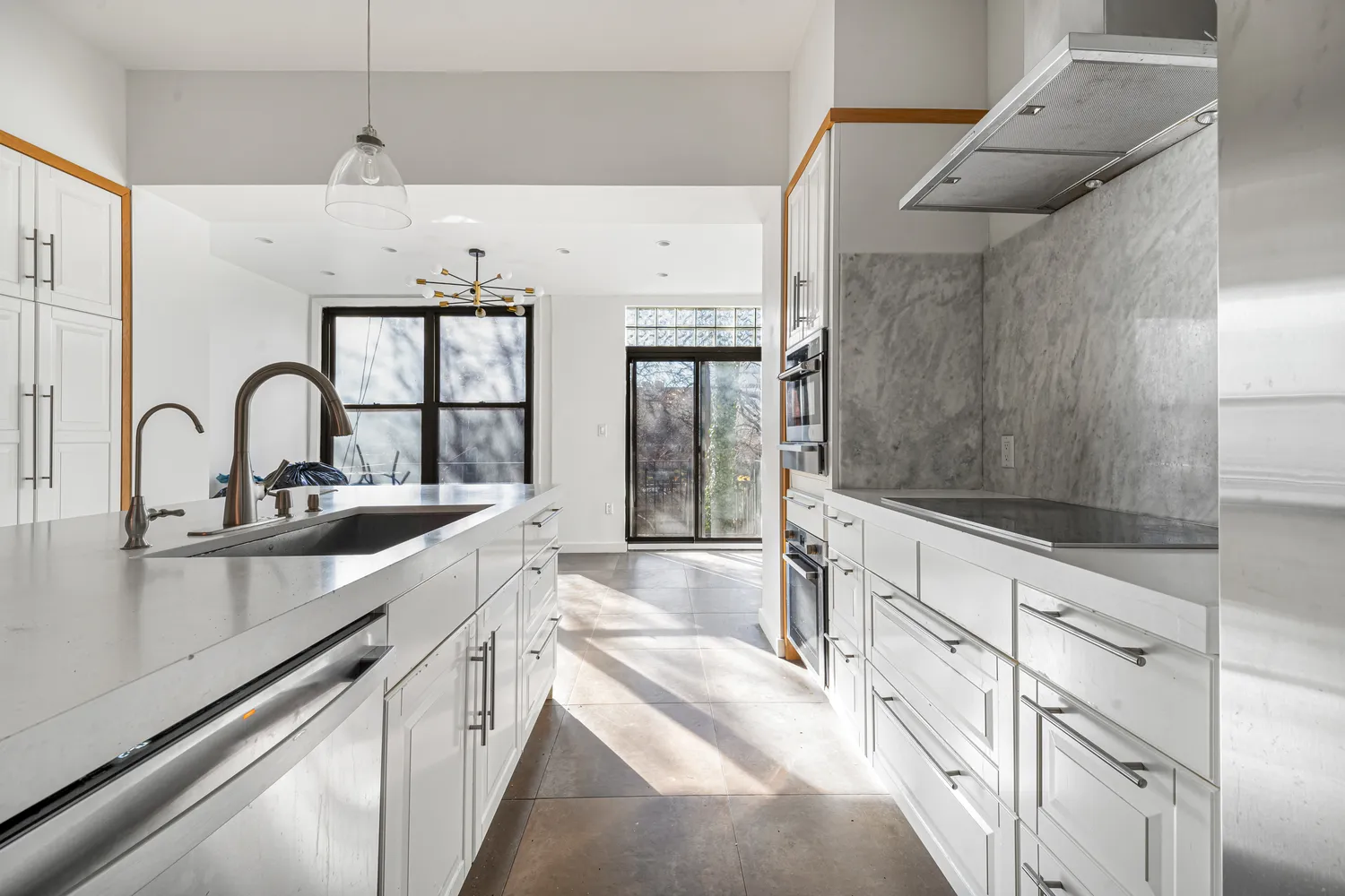 a large kitchen with stainless steel appliances a sink and cabinets