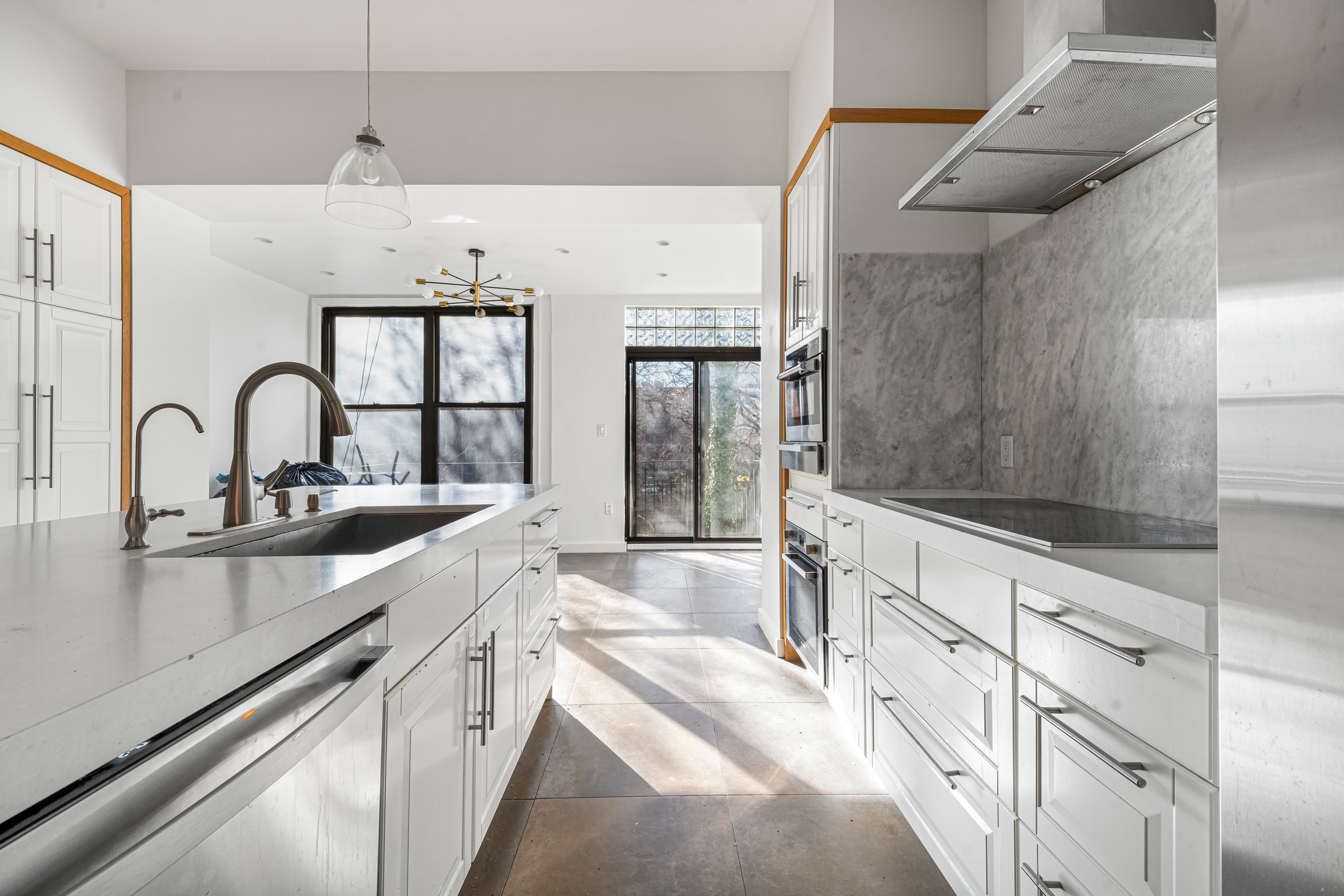 a large kitchen with stainless steel appliances a sink and cabinets