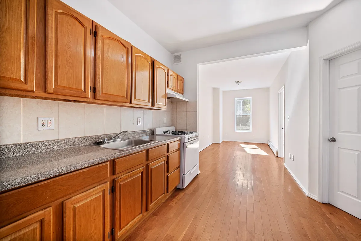 a kitchen with stainless steel appliances granite countertop a sink stove and wooden cabinets