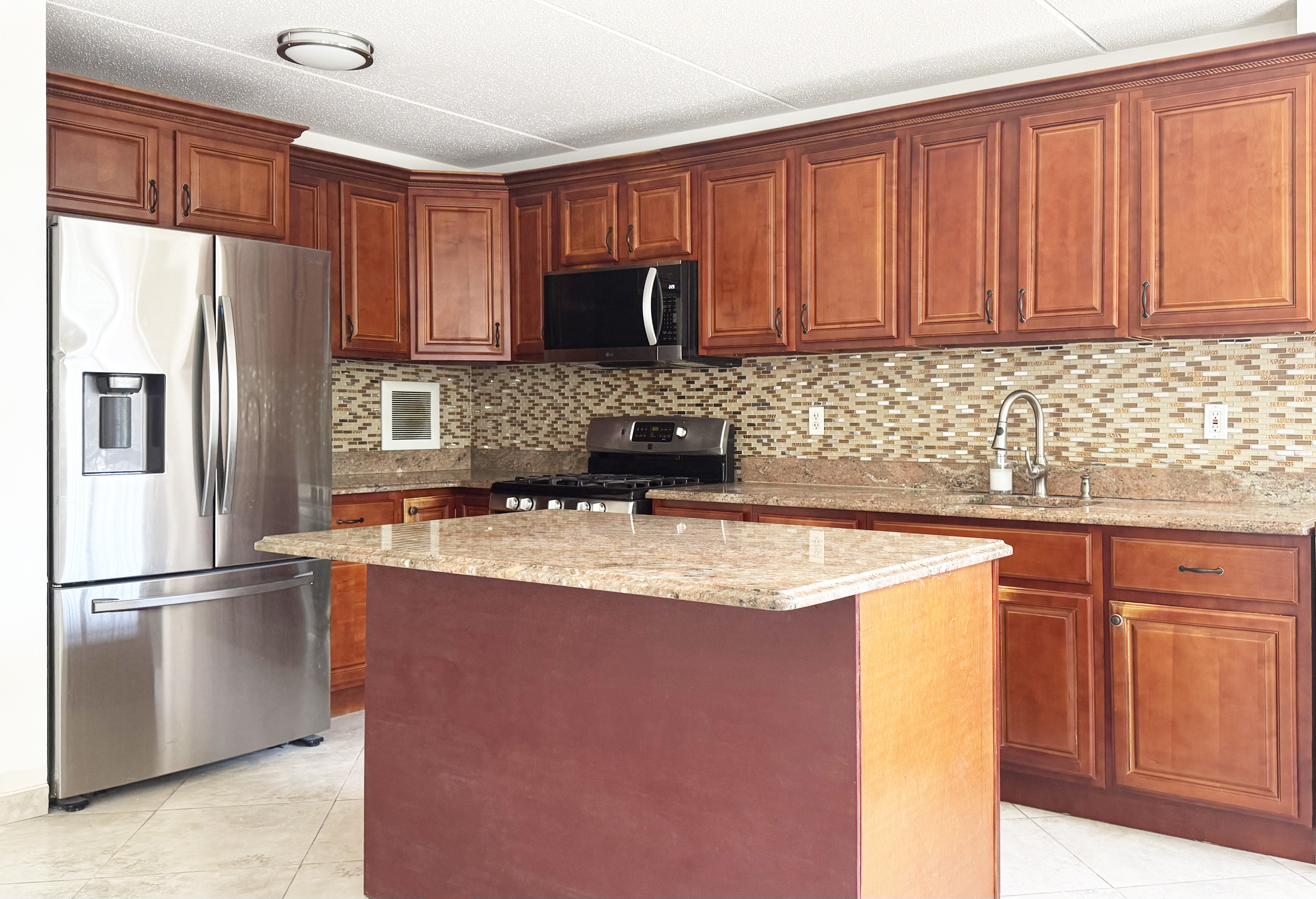 175 Eldert Street, Unit 2 Brooklyn, NY 11207 - Photo 3 of 15 a kitchen with stainless steel appliances granite countertop a refrigerator a sink a stove with wooden cabinets