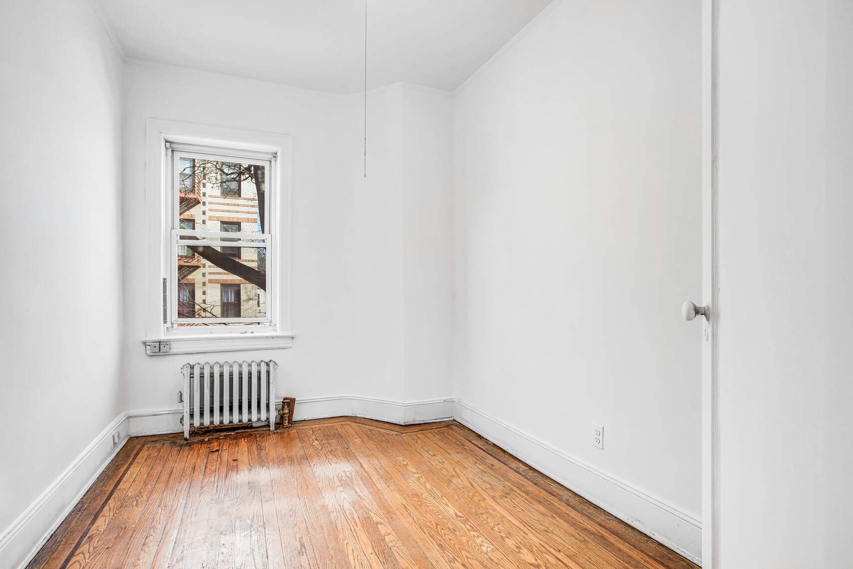 8301 4th Avenue Brooklyn, NY 11209 - Photo 9 of 20 a view of an empty room with wooden floor and a window