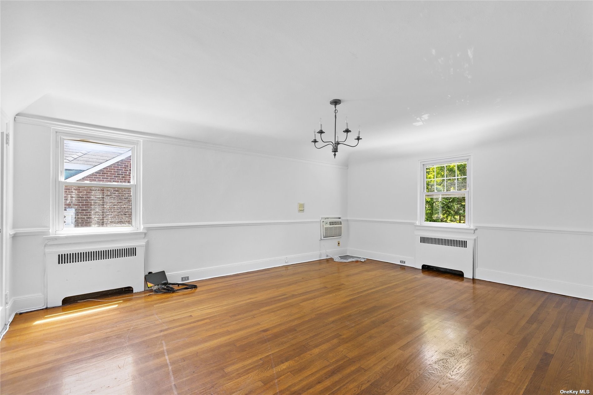 85-23 Edgerton Boulevard Queens, NY 11432 - Photo 16 of 36 wooden floor in an empty room with a window