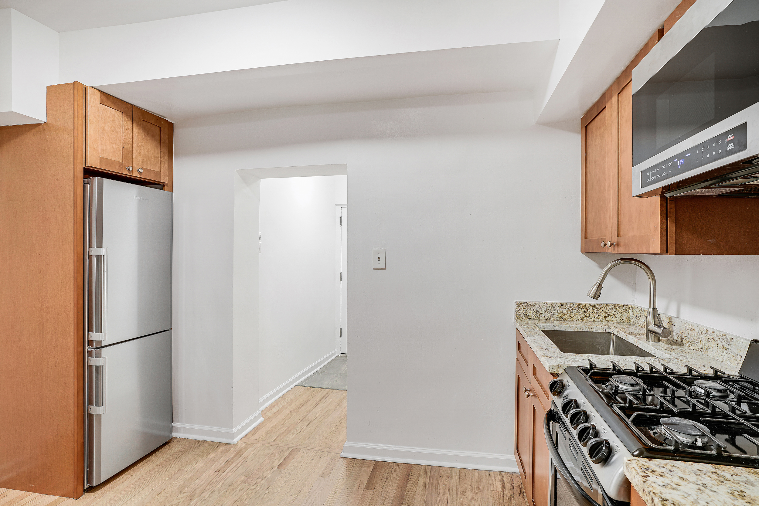433 East 83rd Street, Unit B2 Manhattan, NY 10028 - Photo 2 of 5 a kitchen with stainless steel appliances granite countertop a refrigerator and a sink