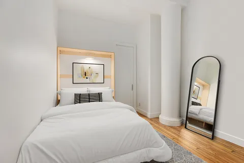 a bedroom with a bed and a mirror