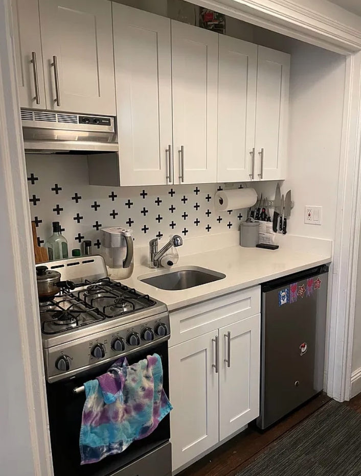 433 West 34th Street, Unit 10C Manhattan, NY 10001 - Photo 2 of 8 a kitchen with white cabinets and appliances