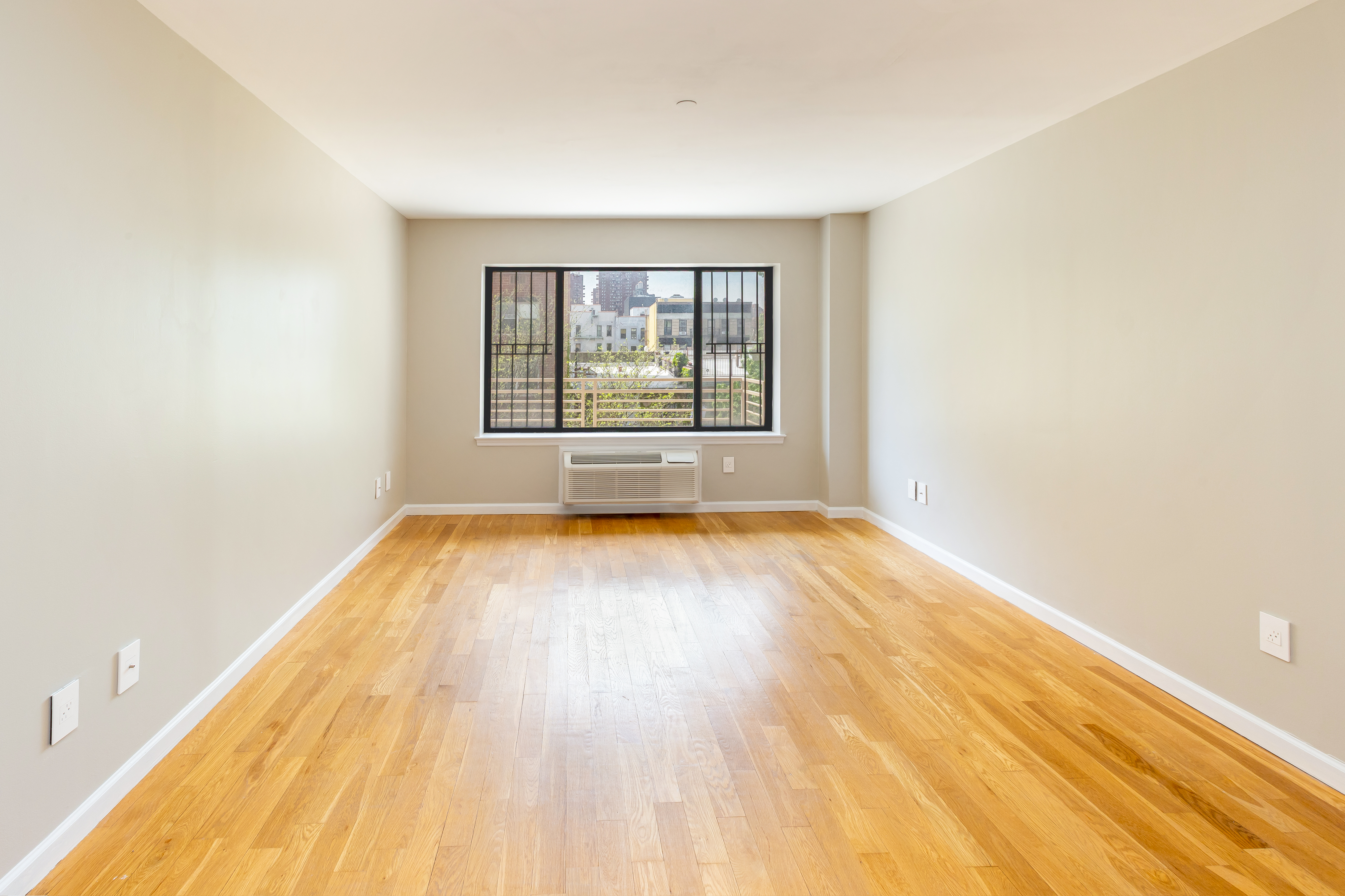 416 East 117th Street, Unit 5A Manhattan, NY 10035 - Photo 6 of 16 an empty room with wooden floor and windows