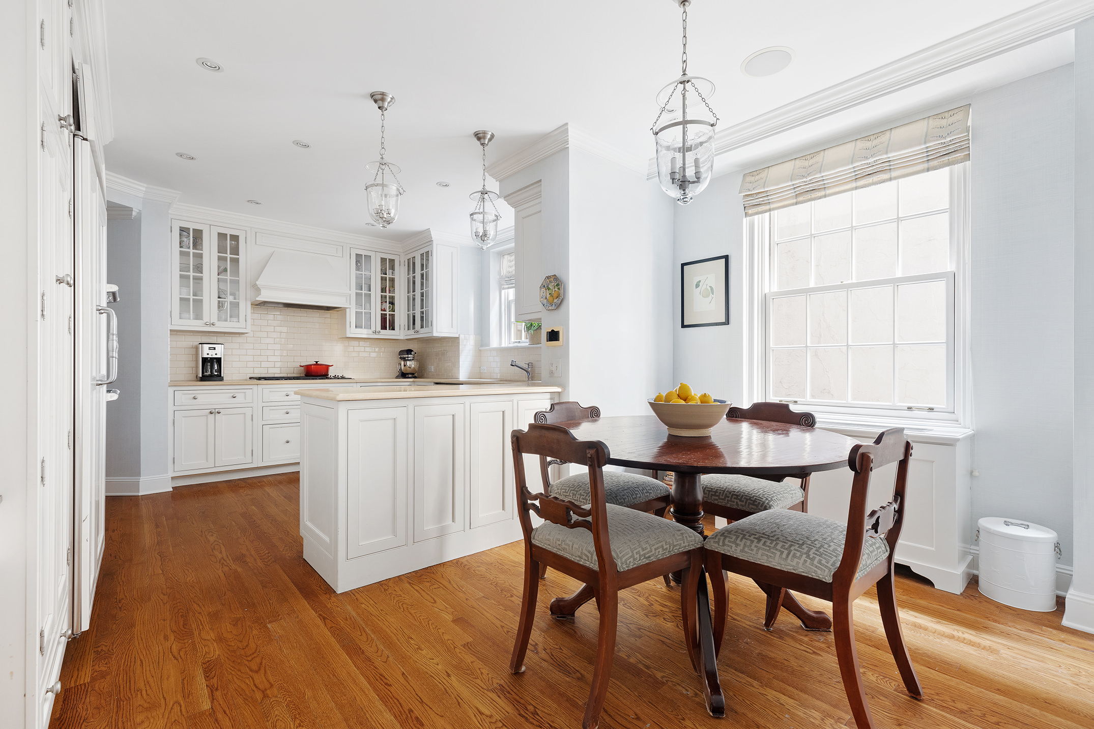 133 East 80th Street, Unit 3A Manhattan, NY 10075 - Photo 16 of 19 a kitchen with stainless steel appliances kitchen island granite countertop a table chairs and a white cabinets
