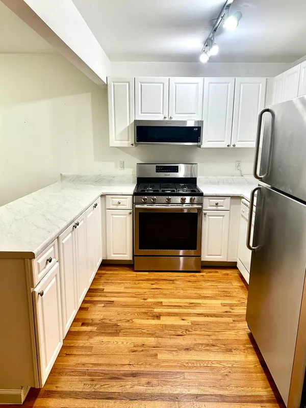 a kitchen with stainless steel appliances granite countertop a stove a sink and a refrigerator
