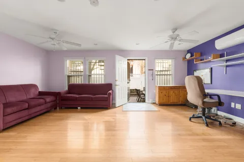 a living room with furniture ceiling fan and a window