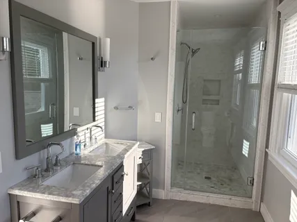 a bathroom with a granite countertop sink a mirror and shower