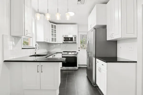 a kitchen with granite countertop a sink stove and refrigerator