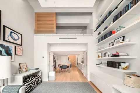 a living room with furniture and a book shelf