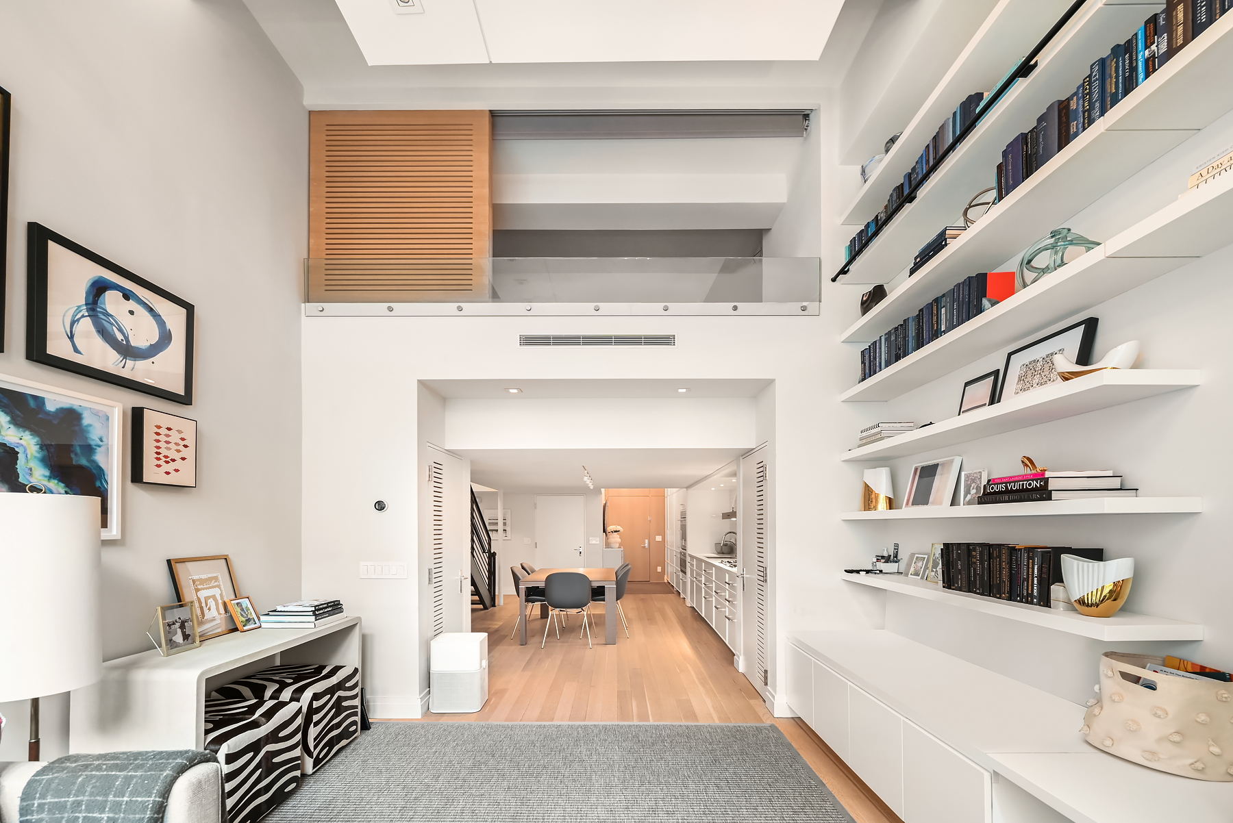 421 Hudson Street, Unit 318 Manhattan, NY 10014 - Photo 2 of 12 a living room with furniture and a book shelf
