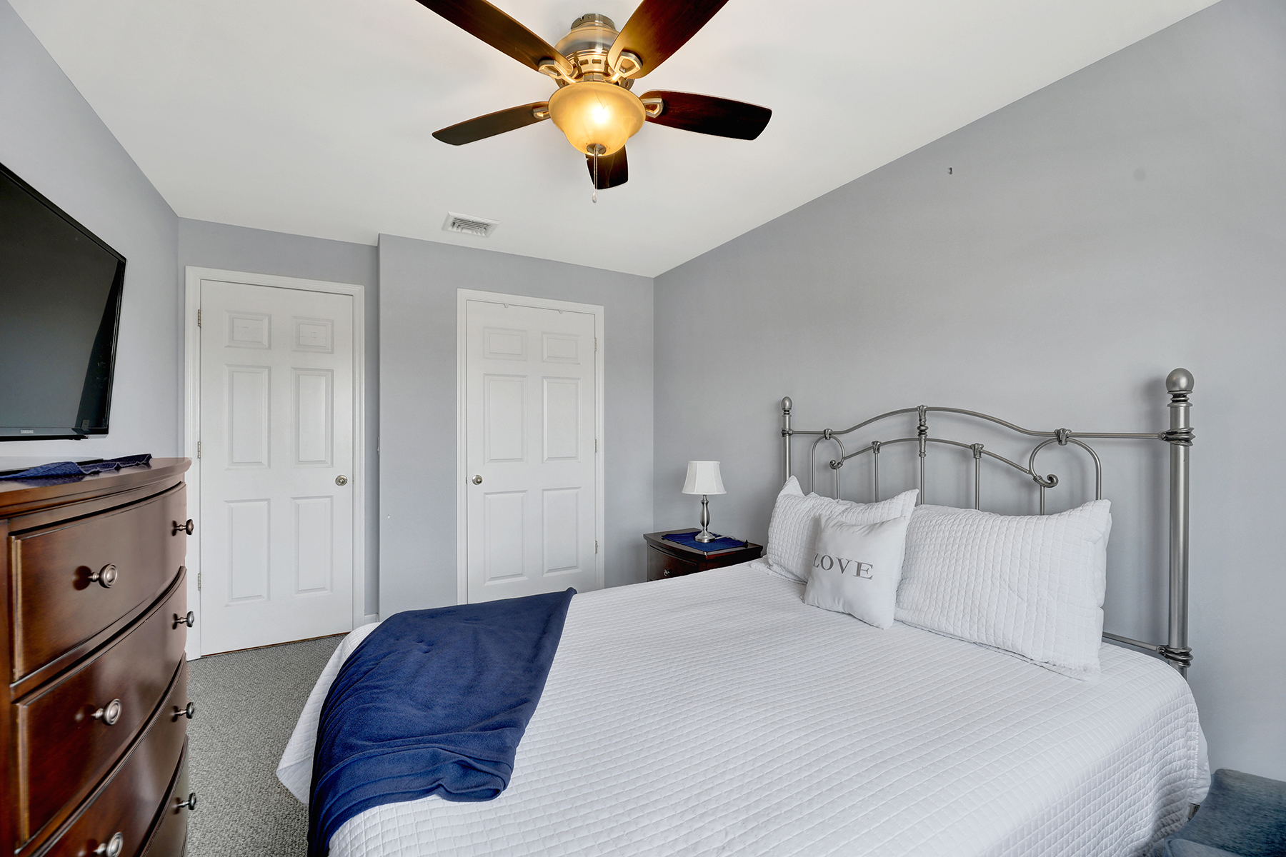 10220 Rockaway Beach Boulevard, Unit 3C Queens, NY 11694 - Photo 26 of 46 a bedroom with a bed and a flat tv screen on dresser