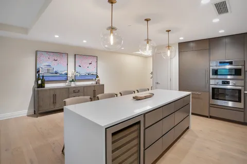 a kitchen with kitchen island a sink stainless steel appliances and cabinets