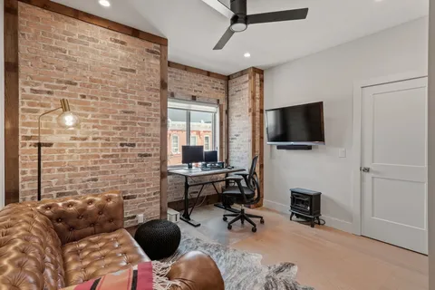 a bedroom with a bed and a flat tv screen on wall