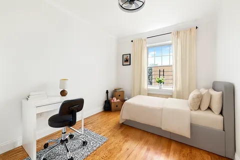 a bedroom with a bed a couch and a window