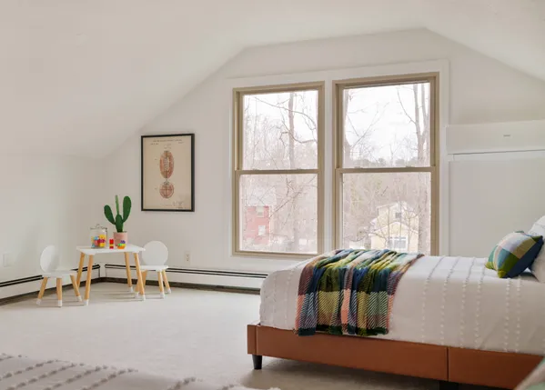 a bedroom with furniture and a large window