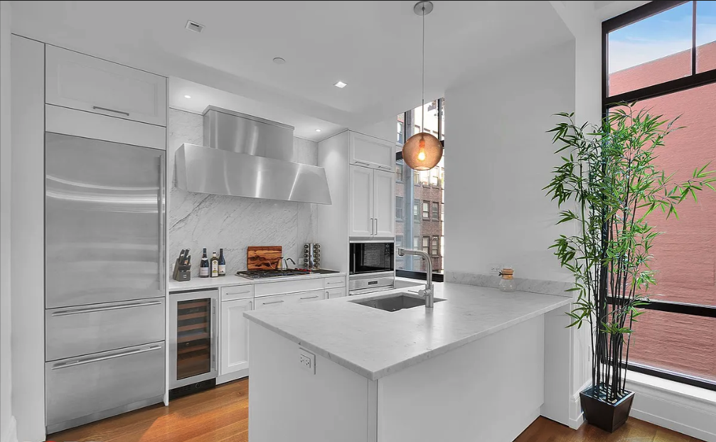10 Madison Square West, Unit 9G Manhattan, NY 10010 - Photo 4 of 13 a kitchen with a sink a potted plant and cabinets