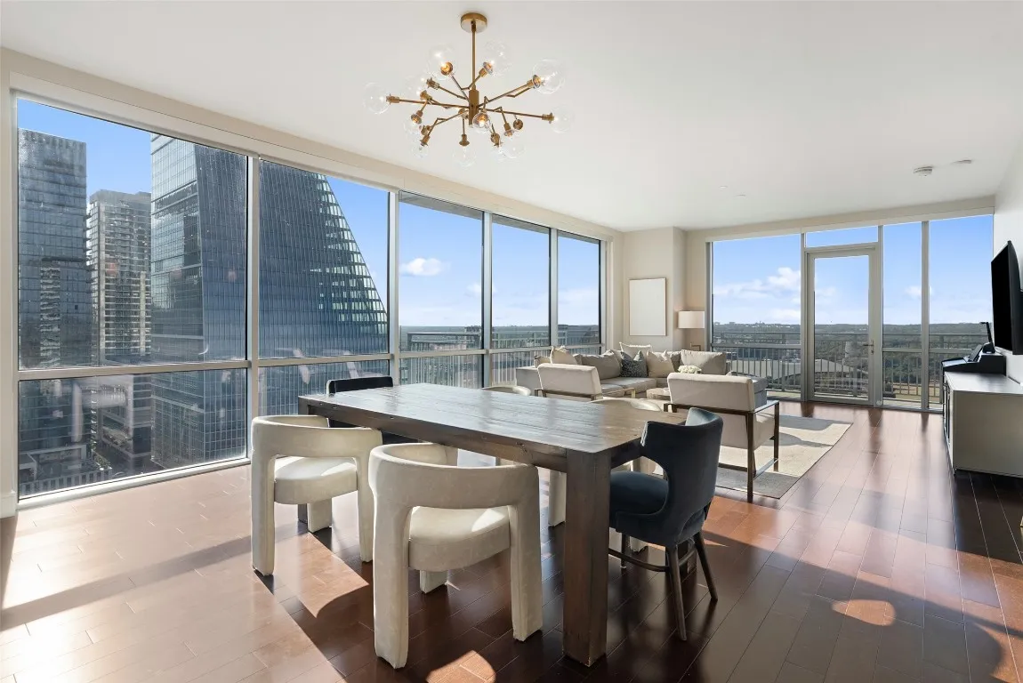 a open dining room with kitchen island furniture a chandelier a large window and kitchen view