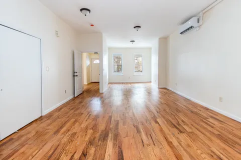 a view of an empty room with wooden floor