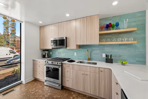 a kitchen with stainless steel appliances granite countertop a stove a sink and a microwave
