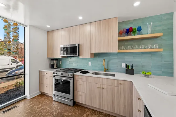 a kitchen with stainless steel appliances granite countertop a stove a sink and a microwave
