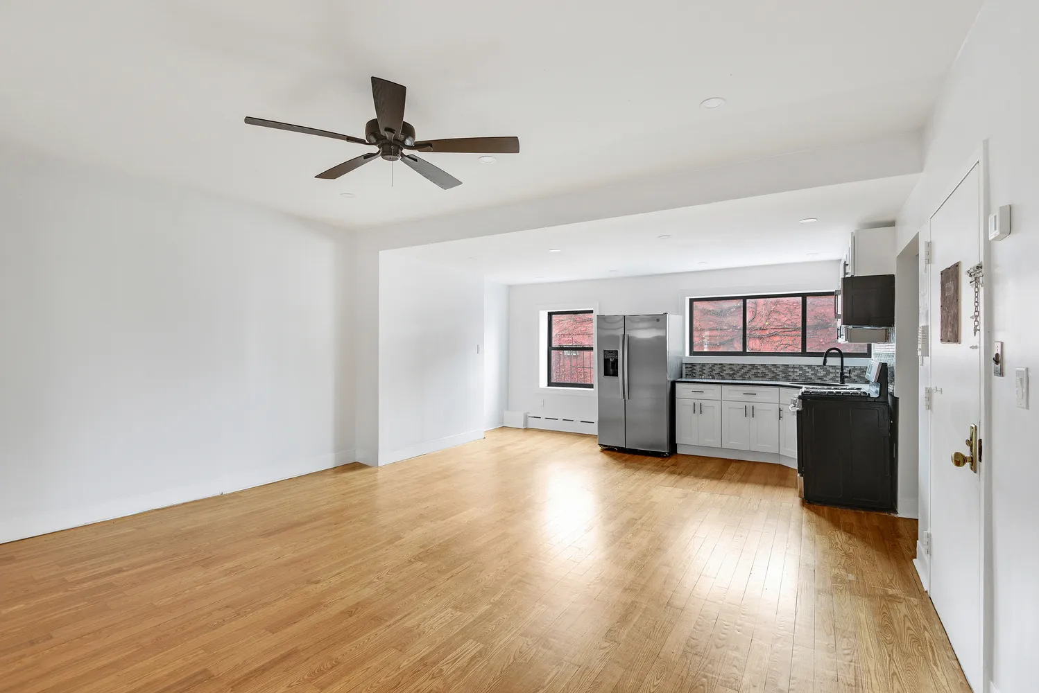 a view of a kitchen with refrigerator and wooden floor