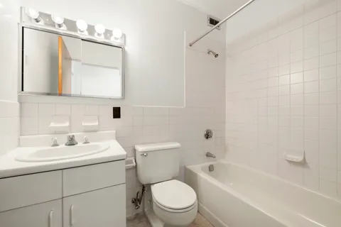 a bathroom with a toilet a sink a mirror a bathtub and shower