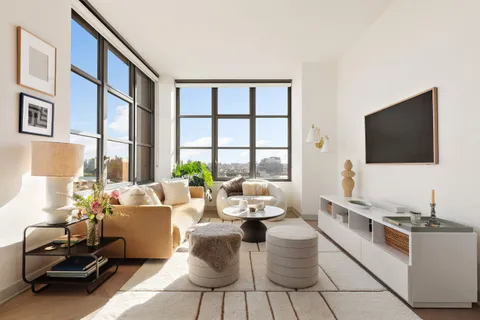 a living room with furniture a flat screen tv and a floor to ceiling window