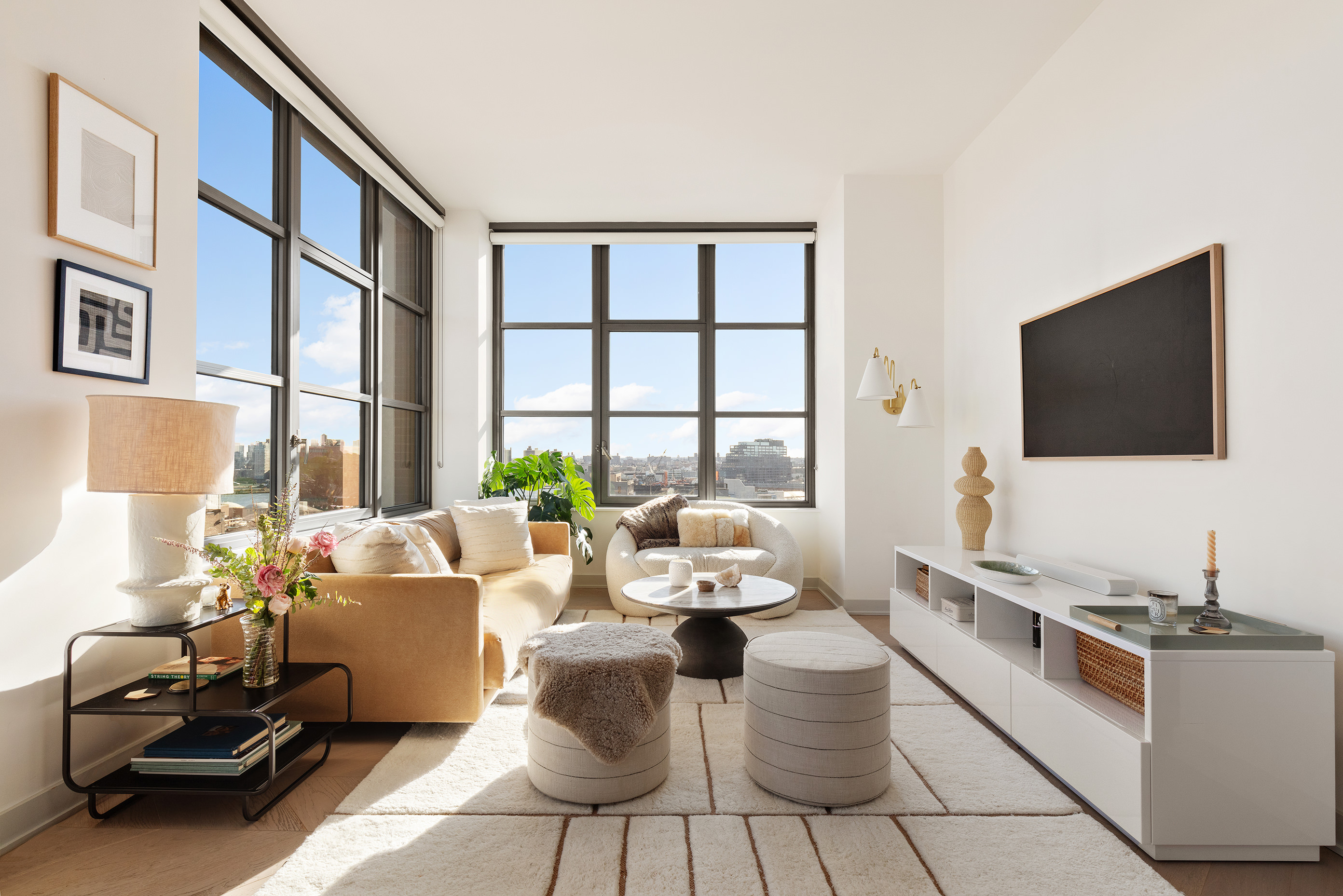 180 Front Street, Unit 11E Brooklyn, NY 11201 - Photo 7 of 27 a living room with furniture a flat screen tv and a floor to ceiling window