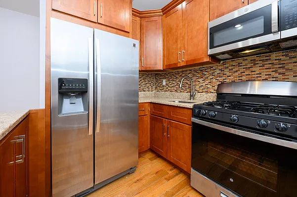 a kitchen with stainless steel appliances granite countertop a refrigerator and a stove