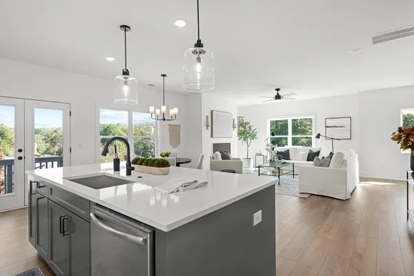 a kitchen with center island white cabinets and a wooden floor