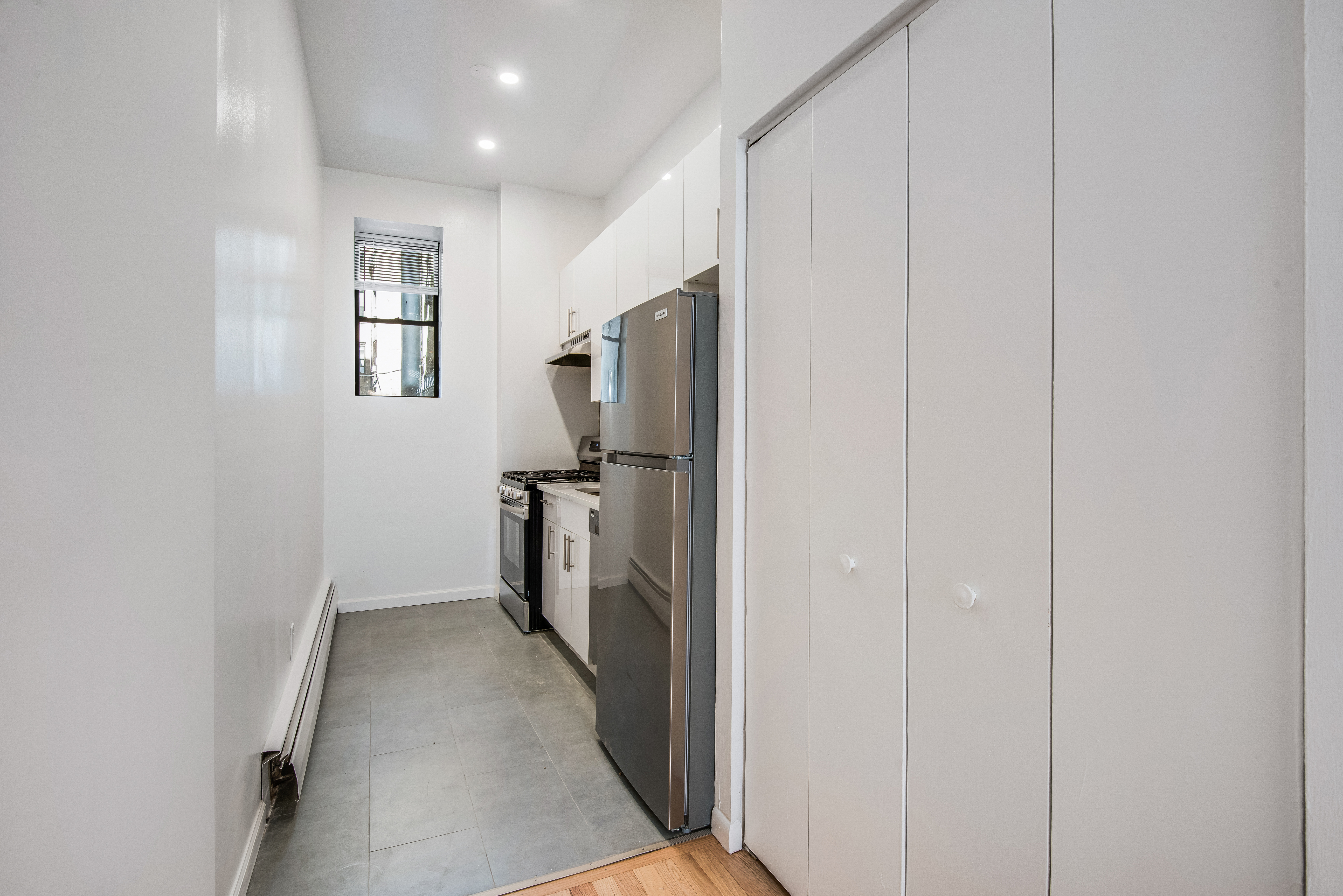 182 East 2nd Street, Unit 1E Manhattan, NY 10009 - Photo 9 of 14 a view of a hallway with a refrigerator and a window