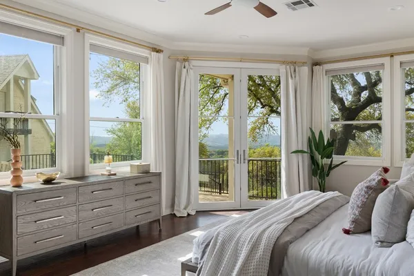 a bedroom with a bed and large windows
