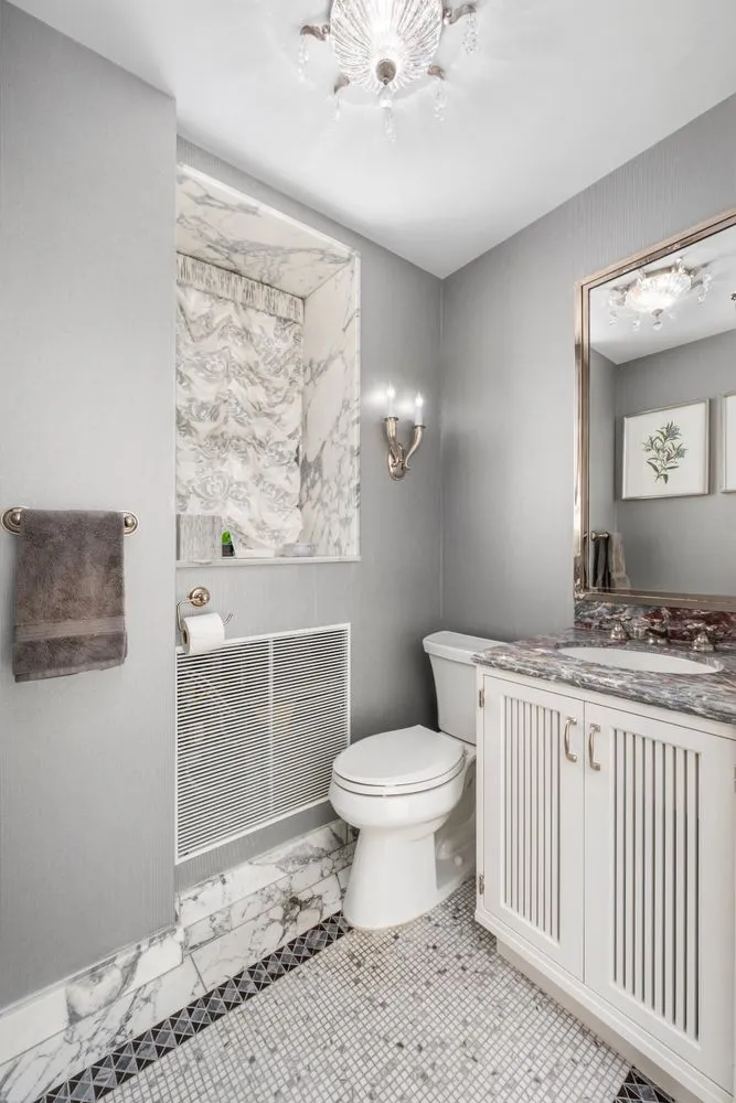 a bathroom with a toilet sink and mirror