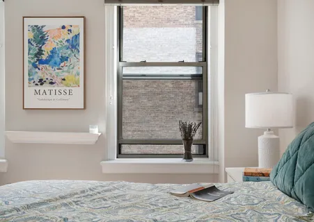 a view of a bedroom with wooden floor and a window