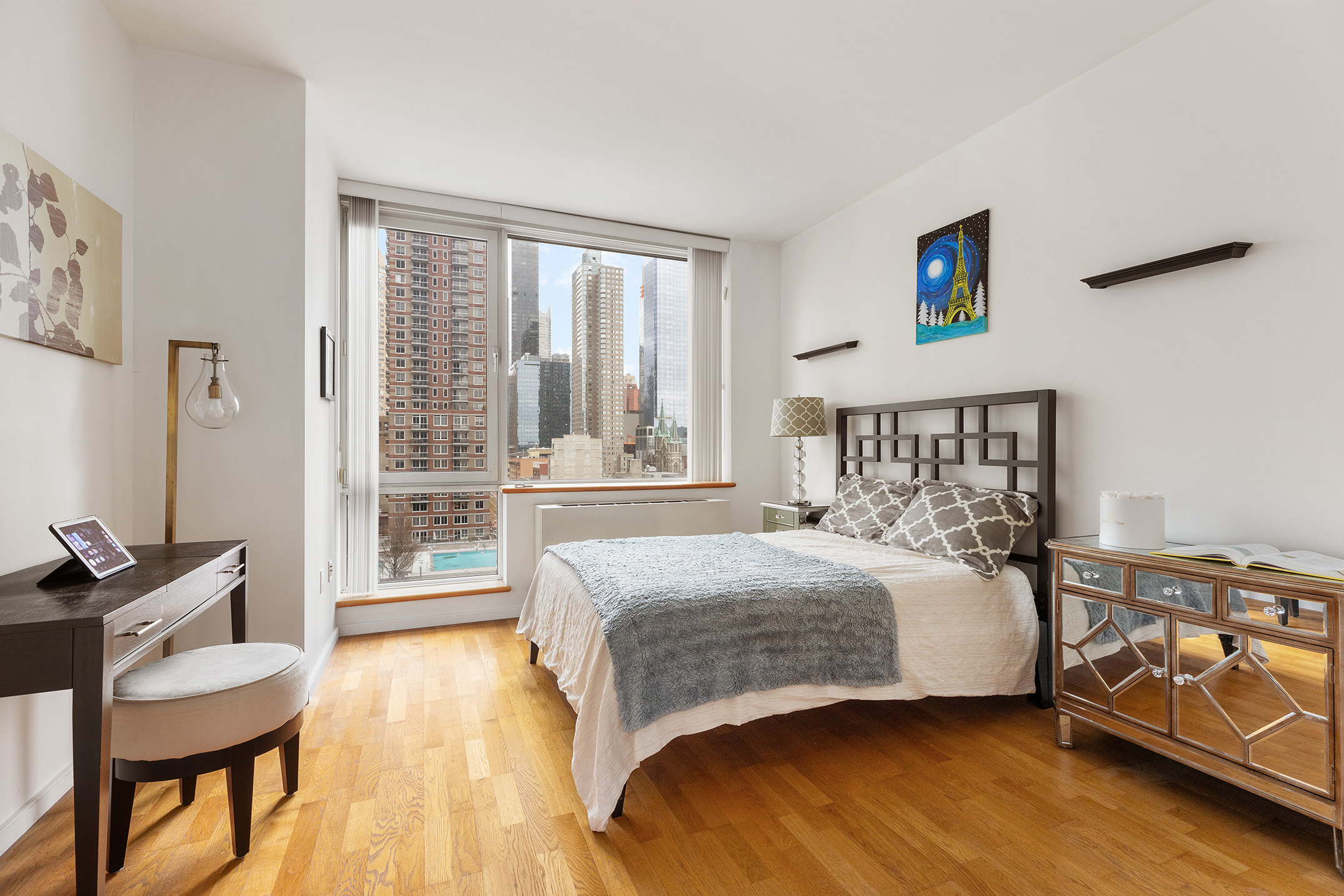 635 West 42nd Street, Unit 7F Manhattan, NY 10036 - Photo 4 of 7 a bedroom with a bed and wooden floor