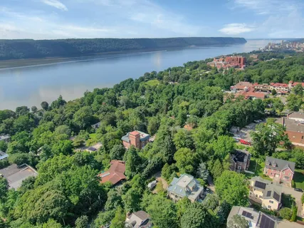 an aerial view of a house with a yard and lake view