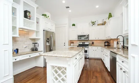 a large kitchen with stainless steel appliances kitchen island granite countertop a sink and cabinets