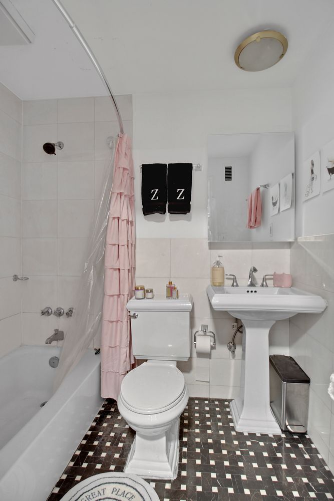 408 8th Avenue, Unit 8B Manhattan, NY 10001 - Photo 8 of 12 a bathroom with a sink a toilet and a bathtub