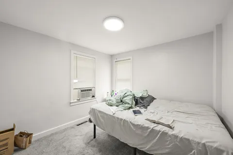 a bed room with a bed and a chair