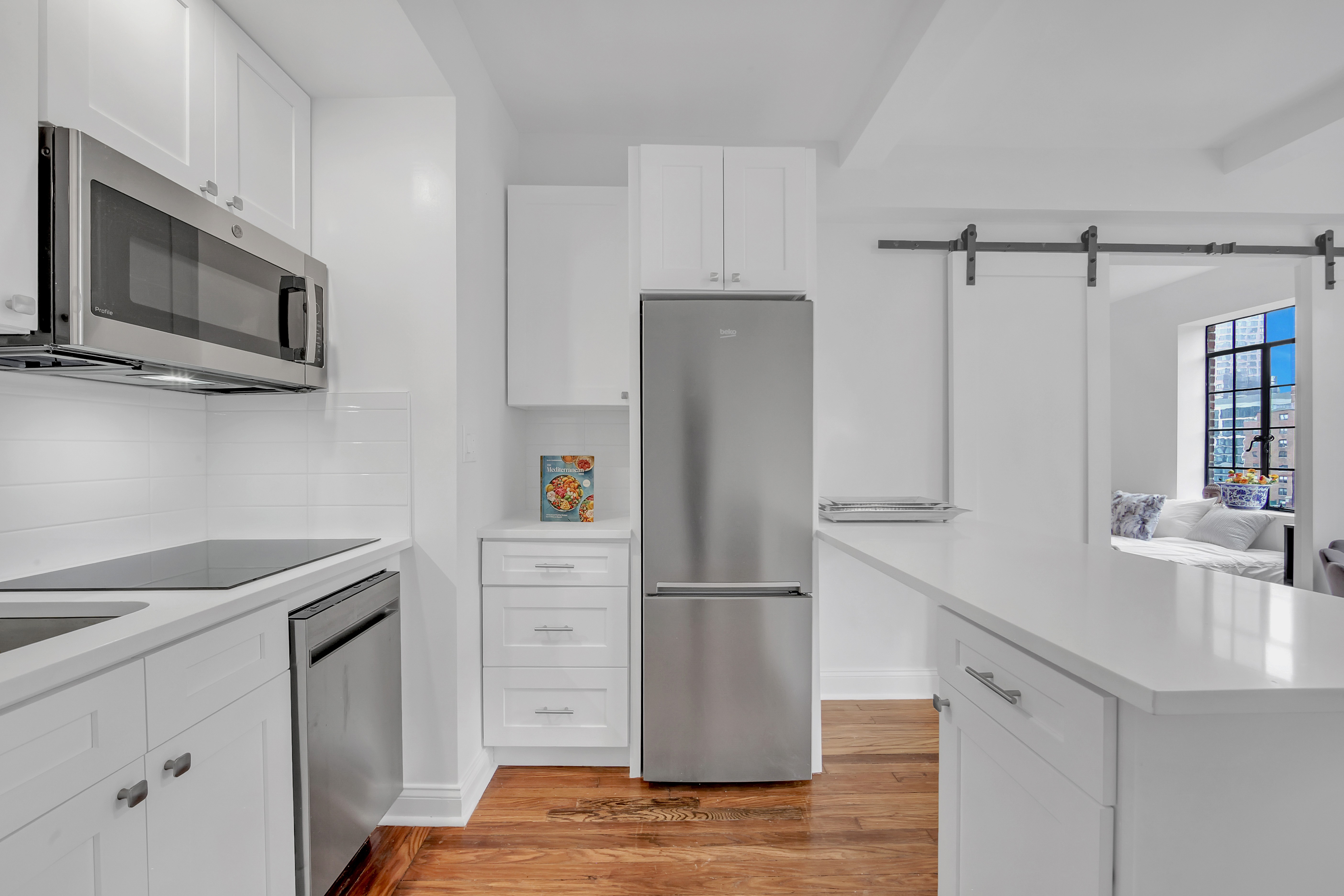 25 Tudor City Place, Unit 1405 Manhattan, NY 10017 - Photo 2 of 21 a kitchen with a refrigerator sink and microwave
