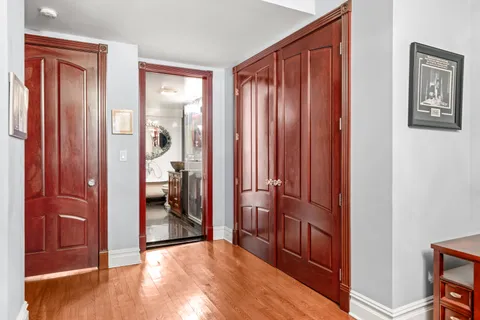 a view of a hallway with bathroom and wooden floor