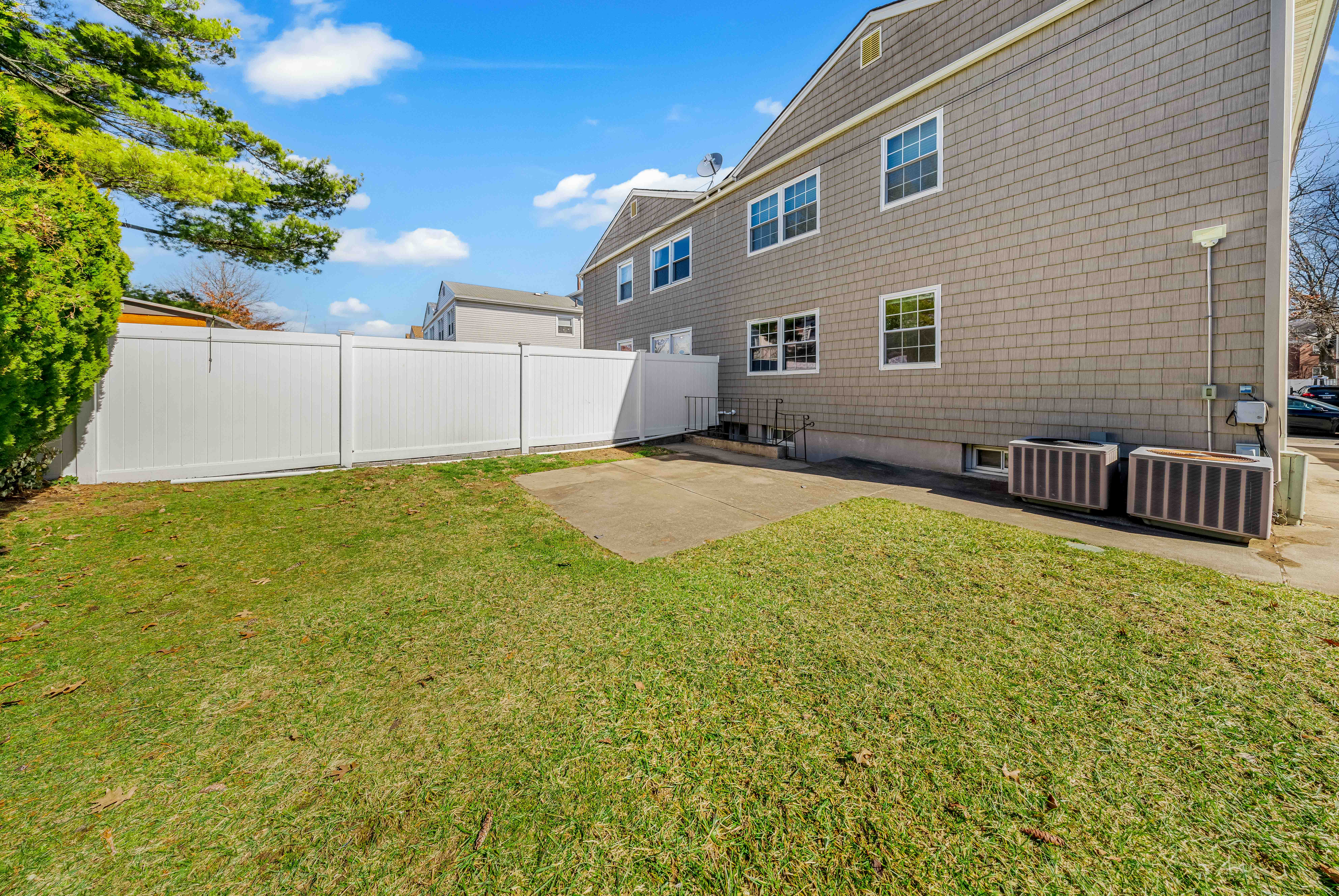 15-80 209th Street, Unit 2 Queens, NY 11360 - Photo 20 of 21 a backyard of a house with table and chairs