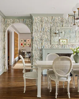 a dining room with wooden floor table and chairs
