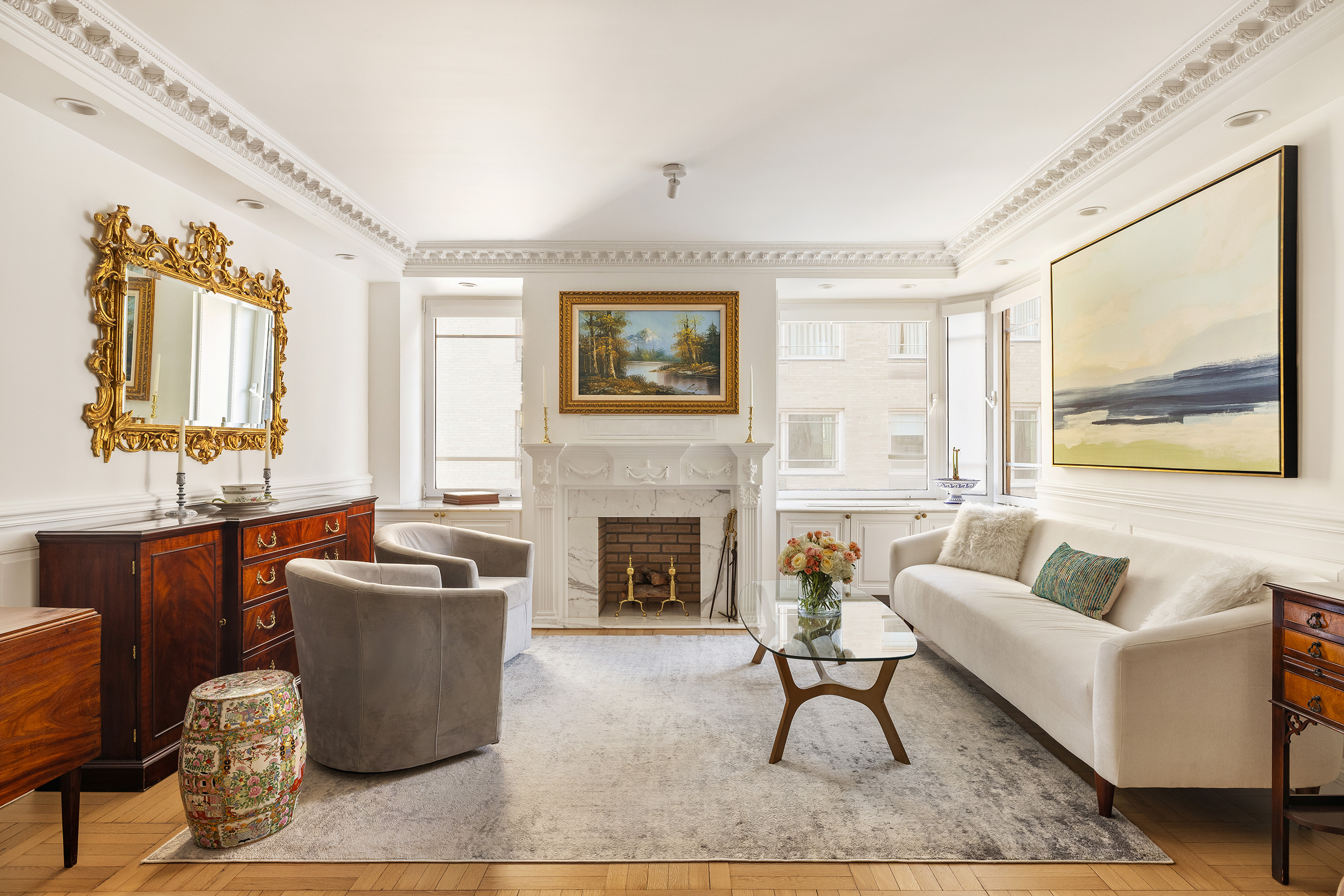 875 5th Avenue, Unit 8D Manhattan, NY 10065 - Photo 2 of 13 a living room with furniture a fireplace and a large window