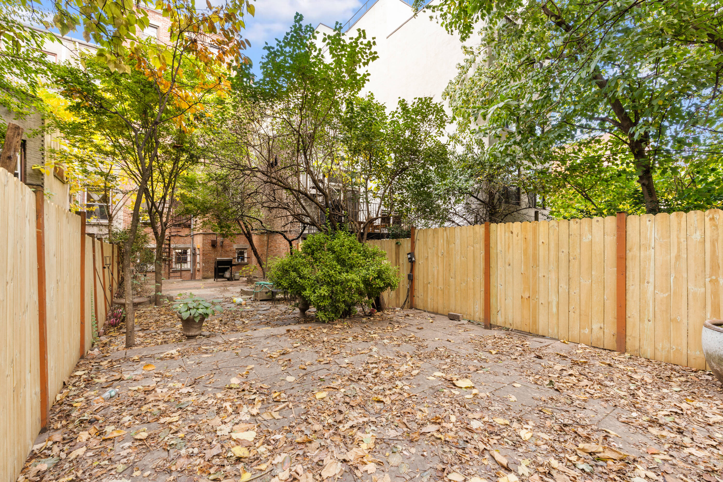 688 Saint Marks Avenue, Unit GARDEN Brooklyn, NY 11216 - Photo 10 of 13 a view of a backyard with large trees and plants